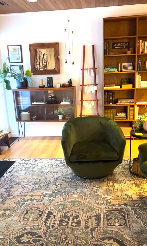 A waiting room with comfortable seating, calm lighting, and midcentury modern decor.